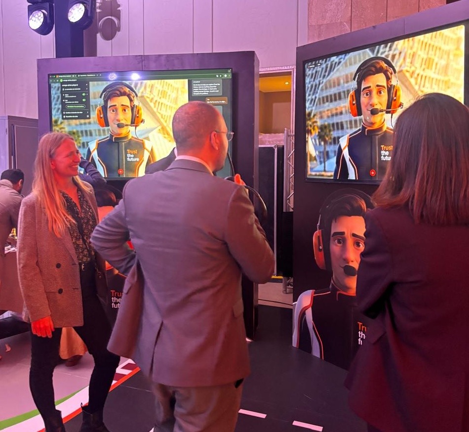 Orange team members conversing around the interactive AIrton kiosk